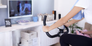 Sporty woman training on exercise bike in the living room,close up